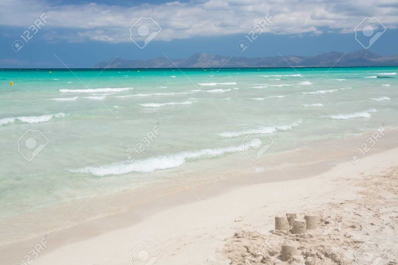 Summer Beach With Emerald Crystal Clear Water And Sand Cakes