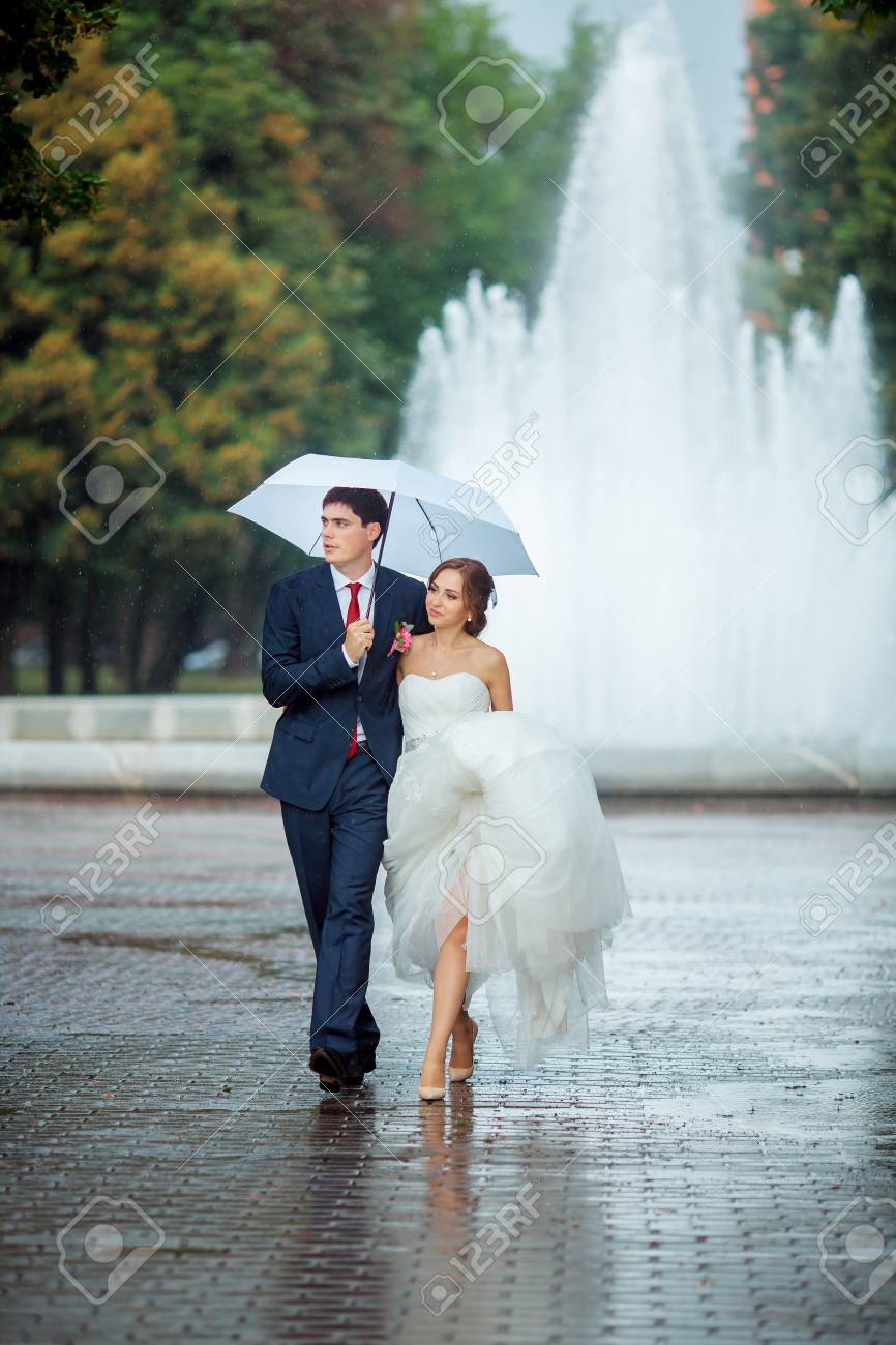 Boda Feliz Pareja En Un Dia De La Boda De Lluvia Al Aire Libre En El Parque Con El Paraguas Blanco En Tiempo De Lluvia La Novia Y El Novio Estan Adoptando