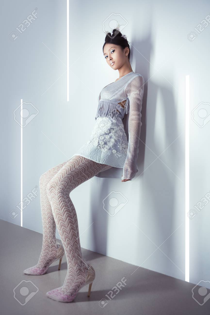 未来的なファッションの若い女性 概念的な髪型とメイクに対して完全な長さでモダンなインテリアと銀都市服で美しい若い多民族アジア白人モデル サイバー ガール Fi のポスターのスタイル の写真素材 画像素材 Image