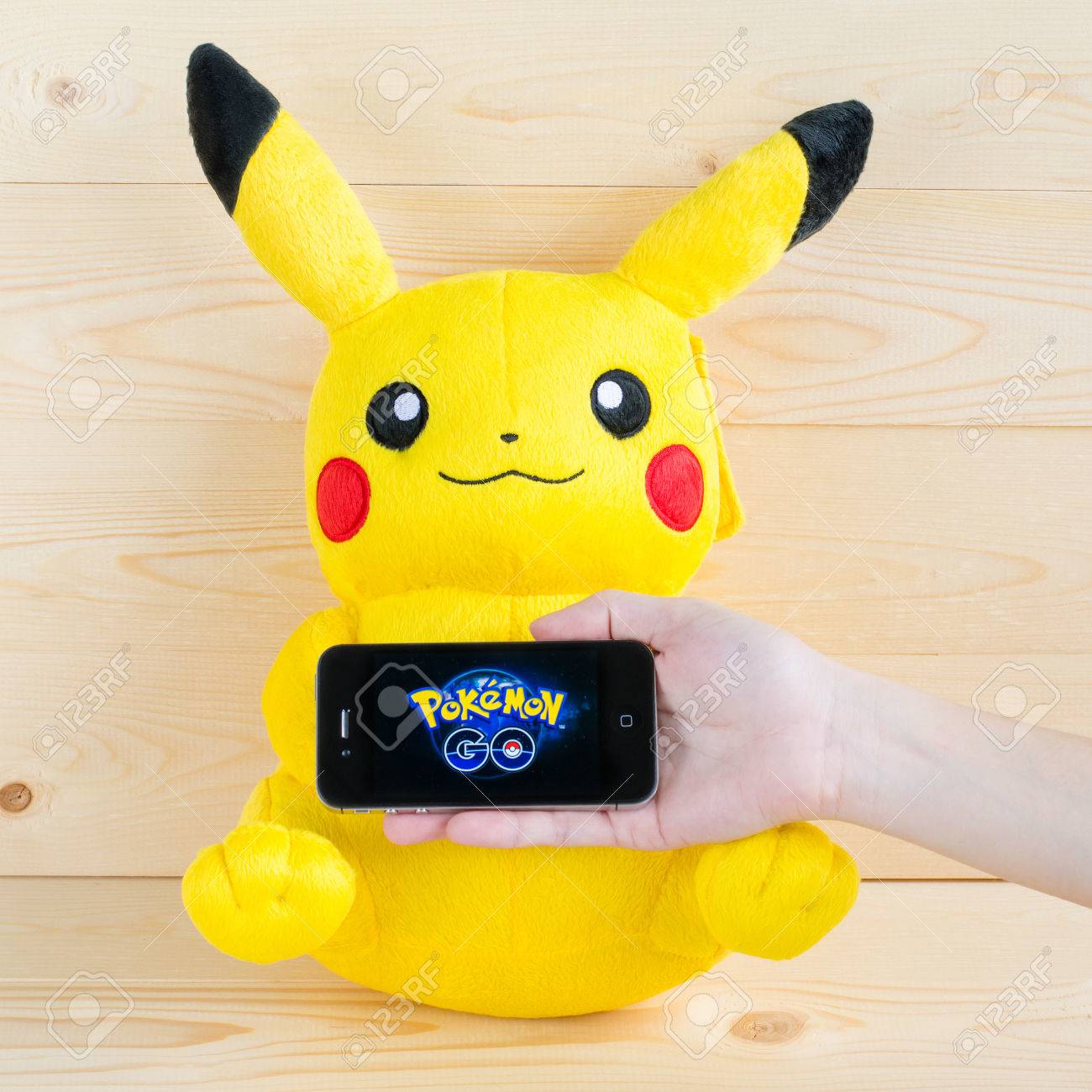 バンコク タイ 16 年 8 月 14 日 ポケモン移動布人形ピカチュウ文字ポケモン移動ゲーム アプリケーション ナイアンティックによって開発された現実モバイル ゲームのスマート フォンを持っている人間の手に座っているの の写真素材 画像素材 Image