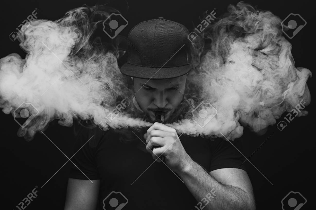 vaping man a cloud of vapor dark background black and white dark vapor
