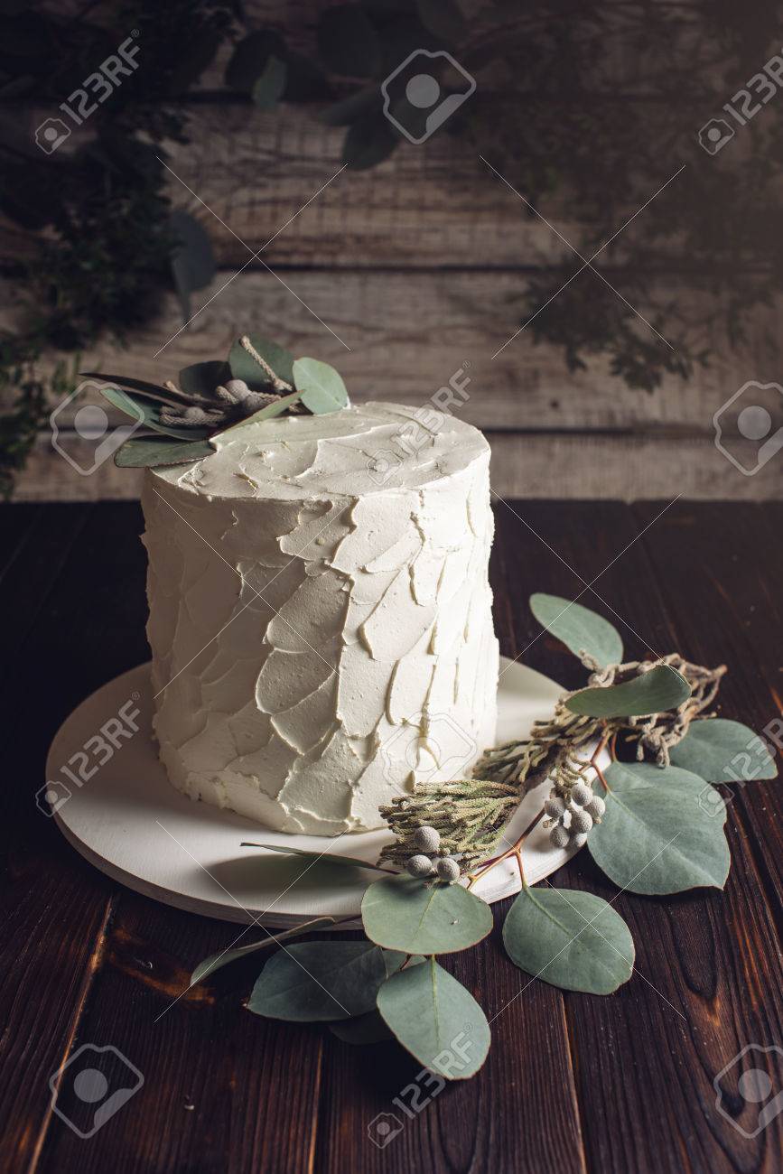 White Cream Cake Decorated With Green Leaves Of The Eucalyptus