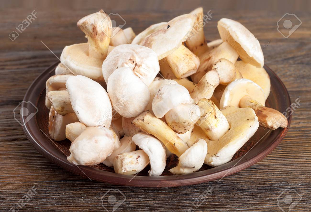 65630108-edible-wild-mushrooms-on-a-wooden-background-forest-cleaned-mushrooms-in-a-clay-plate-.jpg