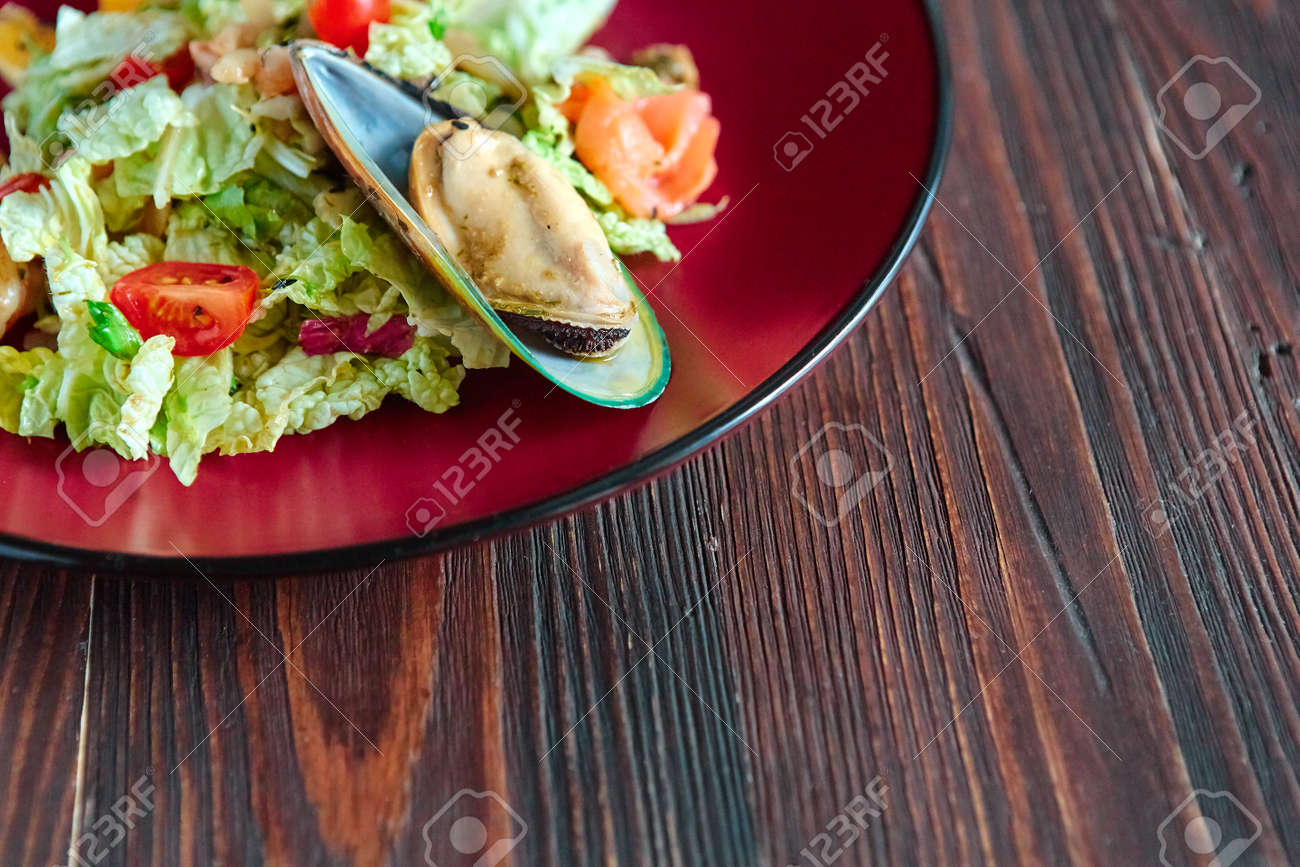 Seafood salad with citrus in a round plate on a gray textured background. - 158618841 Seafood salad with citrus in a round plate on a gray textured background. - 158618841