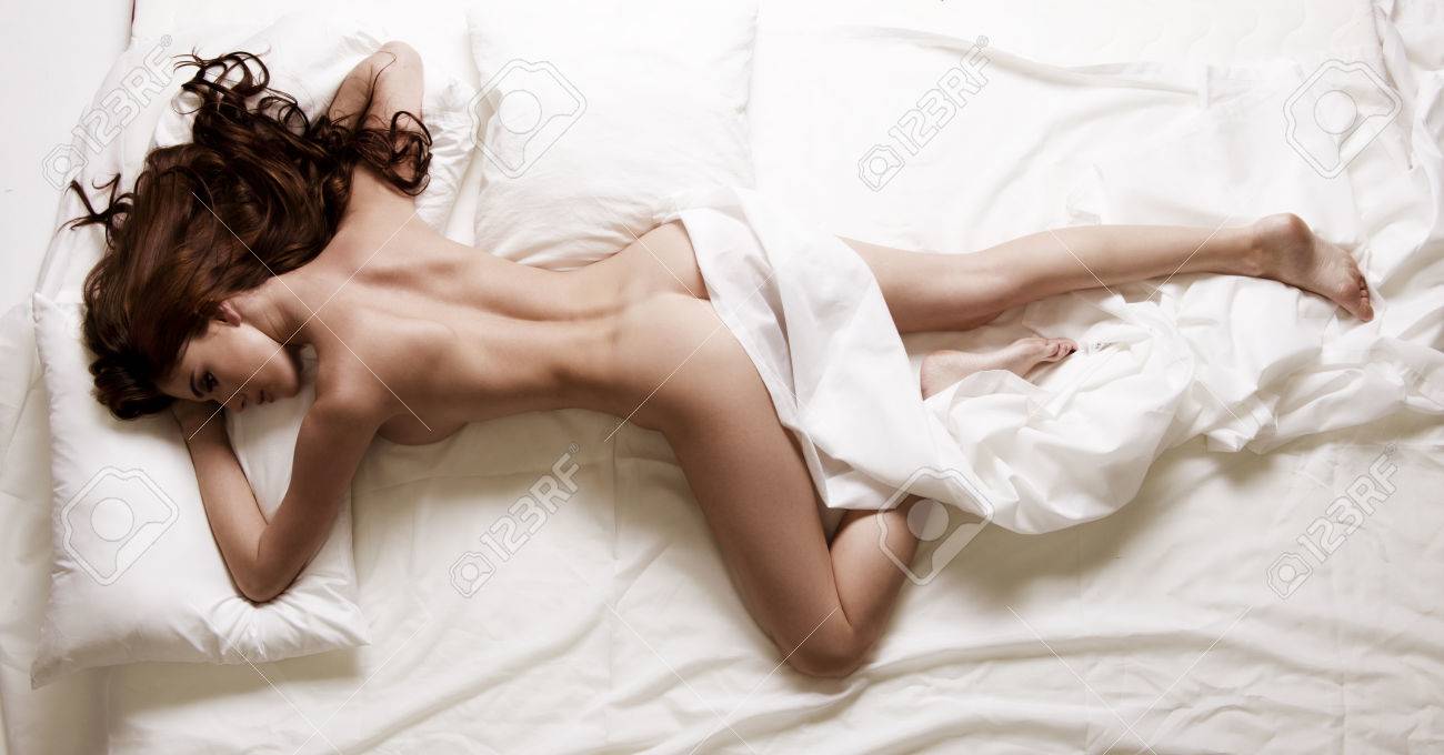 Photo of brunette woman lying in bed. Perfect fitness body. - 60967451