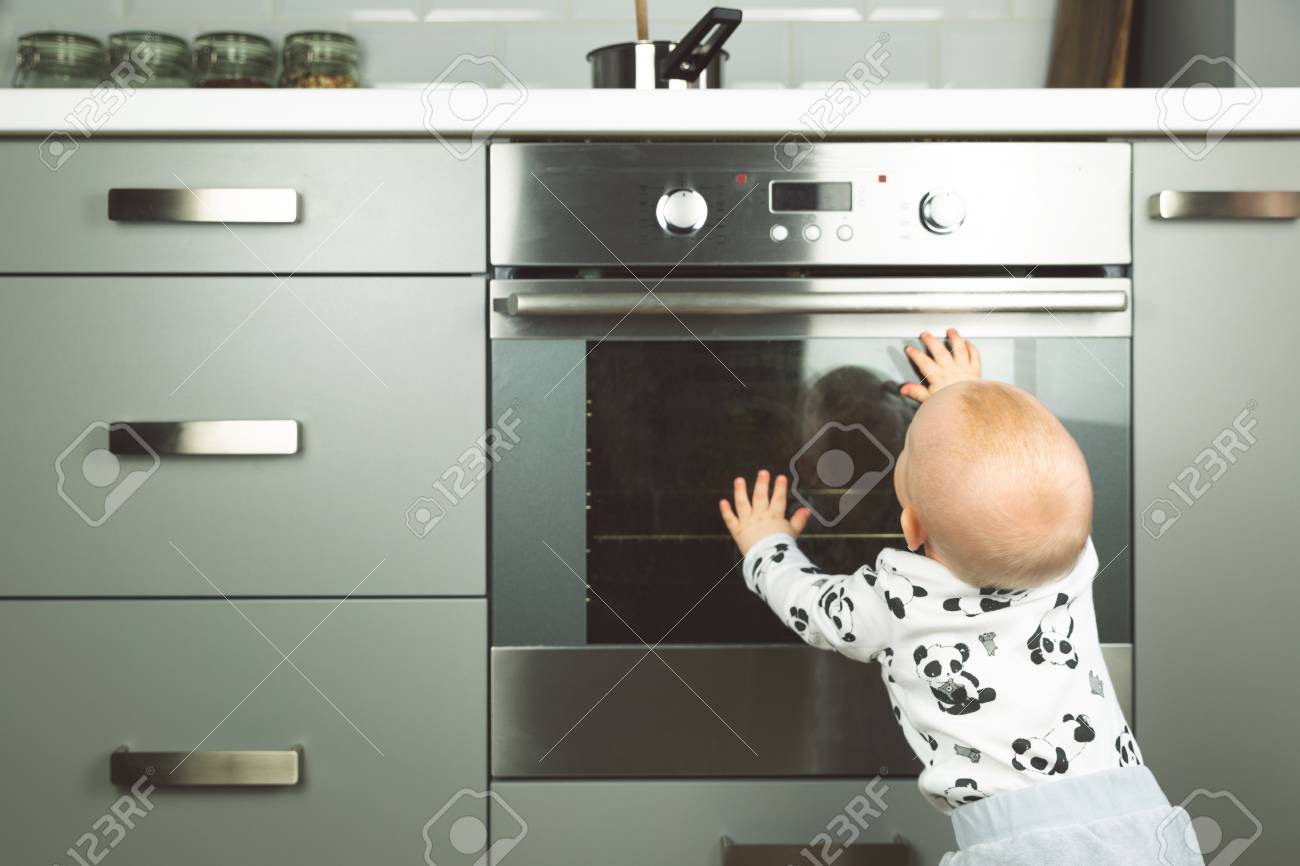 Little Child Playing With Electric Stove In The Kitchen Baby Stock Photo Picture And Royalty Free Image Image 119625193