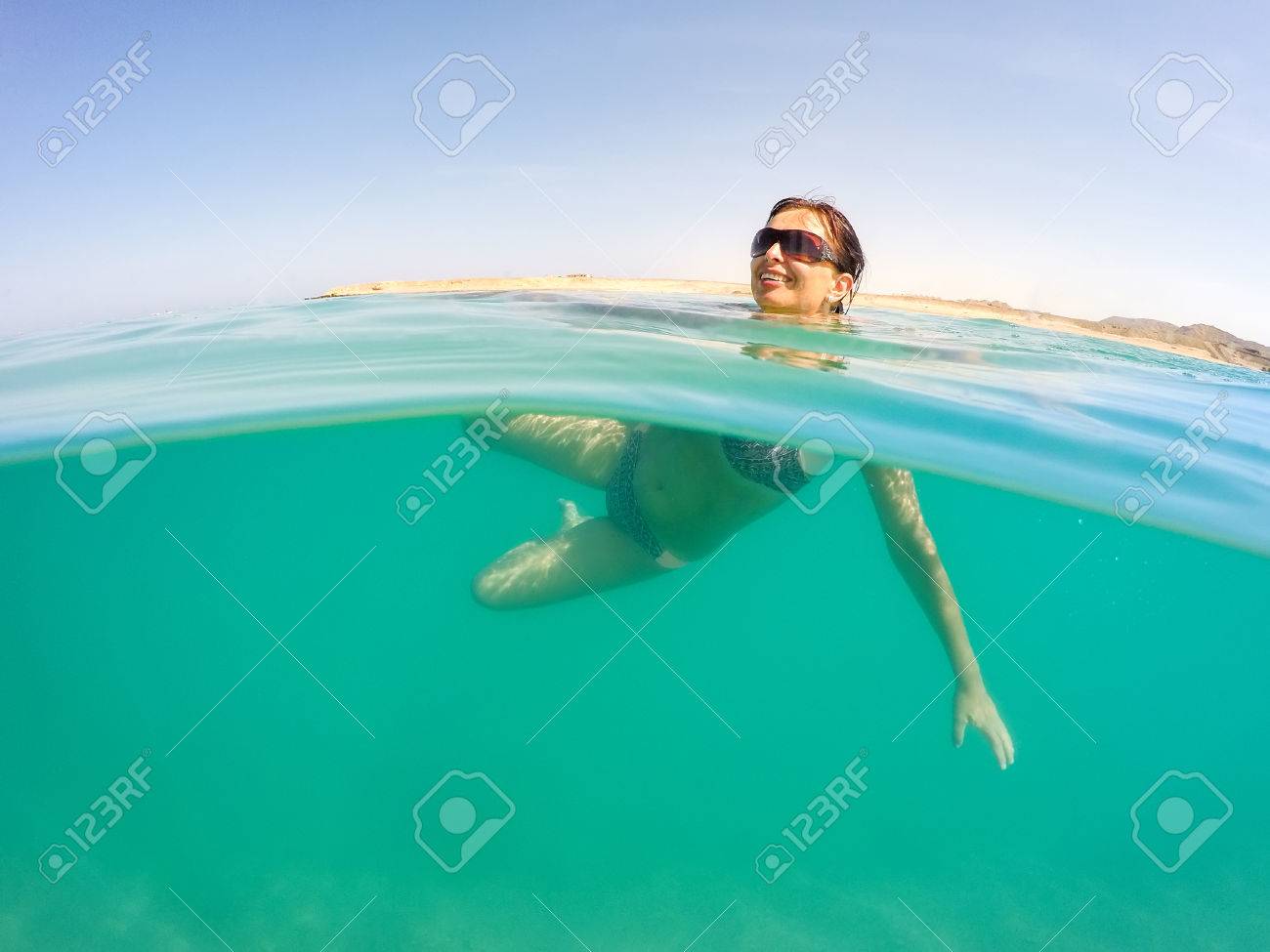 Sexy Busty Middle Age Pretty Woman With Bikini, Bathing Suit, Swimm In Red  Sea In Egypt. Holiday Vacation Concept. Blue Sky With White Clouds And  Clear Turquoise Water. Woman Is Happy With