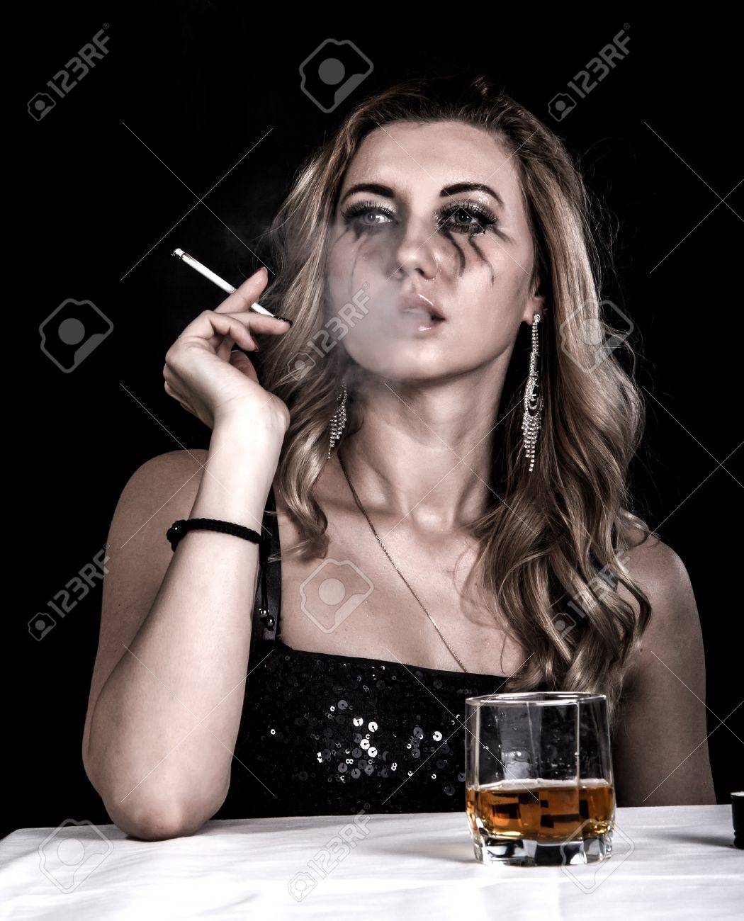 ウイスキーと黒の背景の上のタバコのガラスと落ち込んで若い女性 の写真素材 画像素材 Image