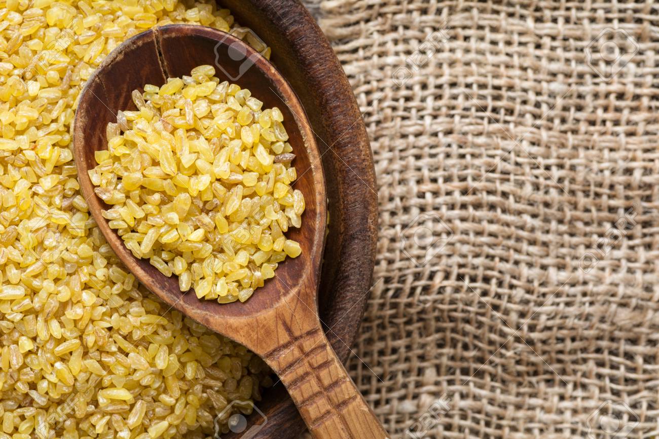 Bulgur, Wheat Grains. Raw Uncooked Bulgur In Wooden Spoon On Linen Textile  Background. Copy Space For Text. Healthy Gluten Free Grains For Cooking  Stock Photo, Picture And Royalty Free Image. Image 69975764.