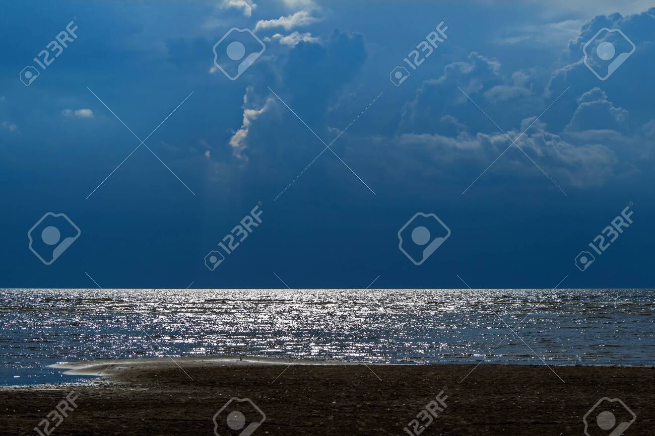The sky is in anticipation of a thunderstorm over lake Peipsi. Last rays break through - 118778459 The sky is in anticipation of a thunderstorm over lake Peipsi. Last rays break through - 118778459