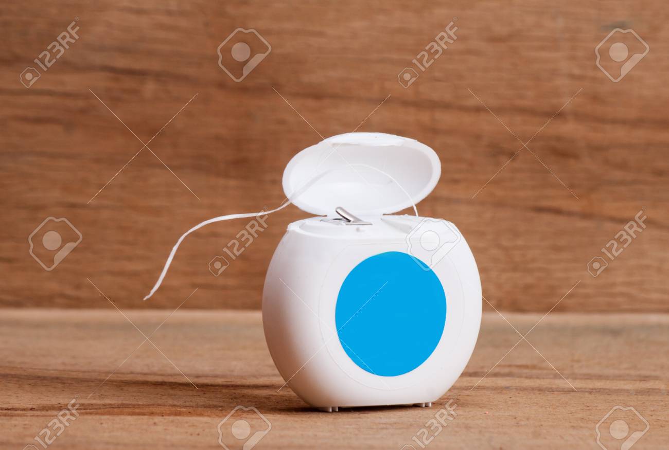 Dental floss on wood desk. Care of teeth - 91686321 Dental floss on wood desk. Care of teeth - 91686321