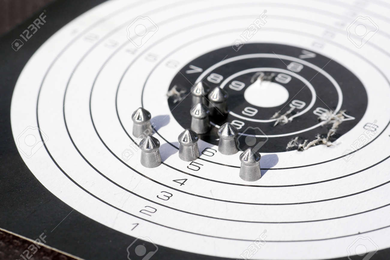 closeup of paper shooting target with bullet holes and airgun pellets - 155844415 closeup of paper shooting target with bullet holes and airgun pellets - 155844415