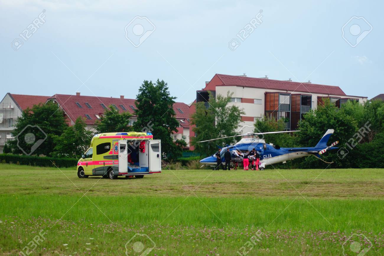 Slovenska Bistrica, July 21 2018: Paramedics hand over patient to Police helicopter for emergency aerial transport to hospital. Ambulance car with flashing lights. Live news. - 109779189 Slovenska Bistrica, July 21 2018: Paramedics hand over patient to Police helicopter for emergency aerial transport to hospital. Ambulance car with flashing lights. Live news. - 109779189