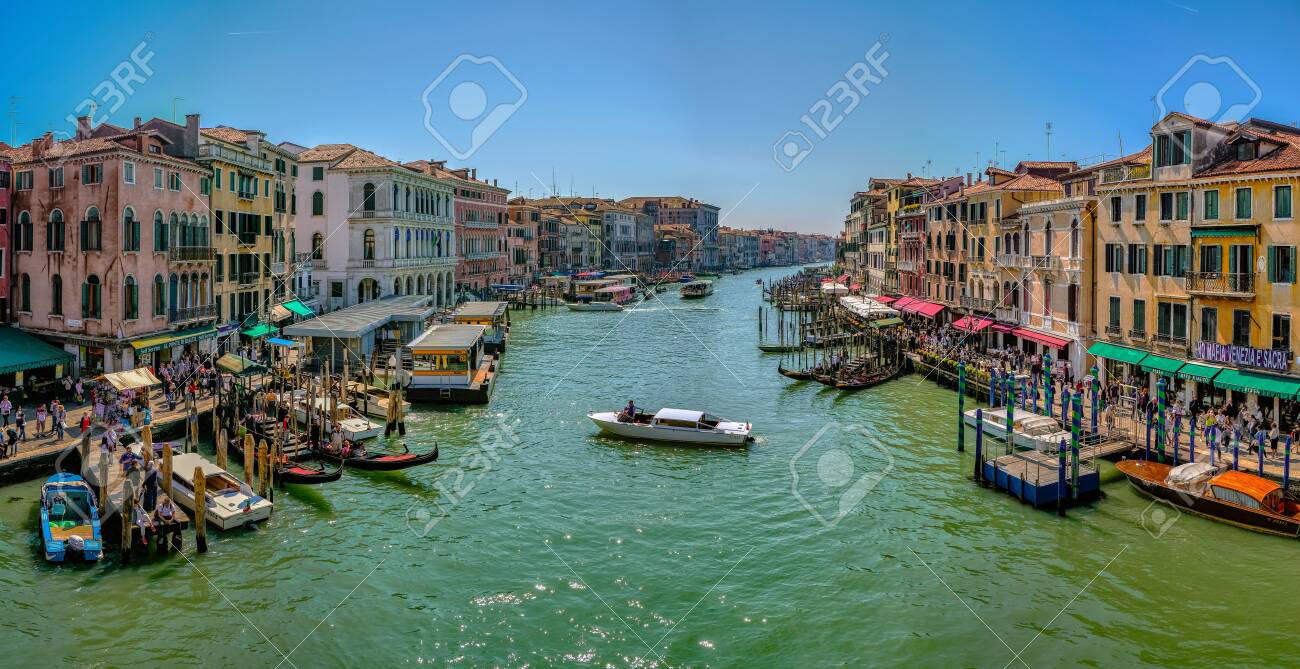 Venice, Italy - April 17 2019: Canale Grande, the Grand Canal in Venice, Italy from the Rialto bridge with gondoals, boats and dense water traffic, tourists walking on shore and sitting in cafes - 137009121 Venice, Italy - April 17 2019: Canale Grande, the Grand Canal in Venice, Italy from the Rialto bridge with gondoals, boats and dense water traffic, tourists walking on shore and sitting in cafes - 137009121