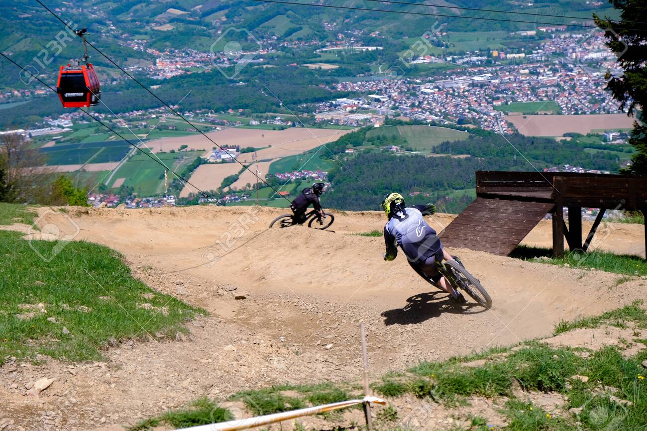 Maribor, Slovenia - May 2, 2019: Downhill mountain bikers riding down the trail on Pohorje near Maribor, Slovenia. Pohorje bike park is very popular with riders. - 137009422 Maribor, Slovenia - May 2, 2019: Downhill mountain bikers riding down the trail on Pohorje near Maribor, Slovenia. Pohorje bike park is very popular with riders. - 137009422