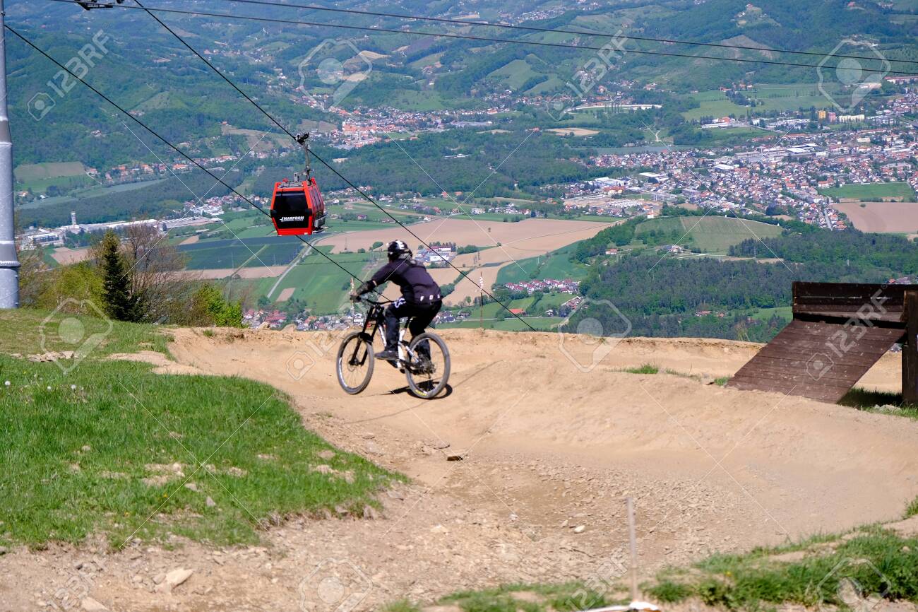Maribor, Slovenia - May 2, 2019: Downhill mountain bikers riding down the trail on Pohorje near Maribor, Slovenia. Pohorje bike park is very popular with riders. - 137010539 Maribor, Slovenia - May 2, 2019: Downhill mountain bikers riding down the trail on Pohorje near Maribor, Slovenia. Pohorje bike park is very popular with riders. - 137010539