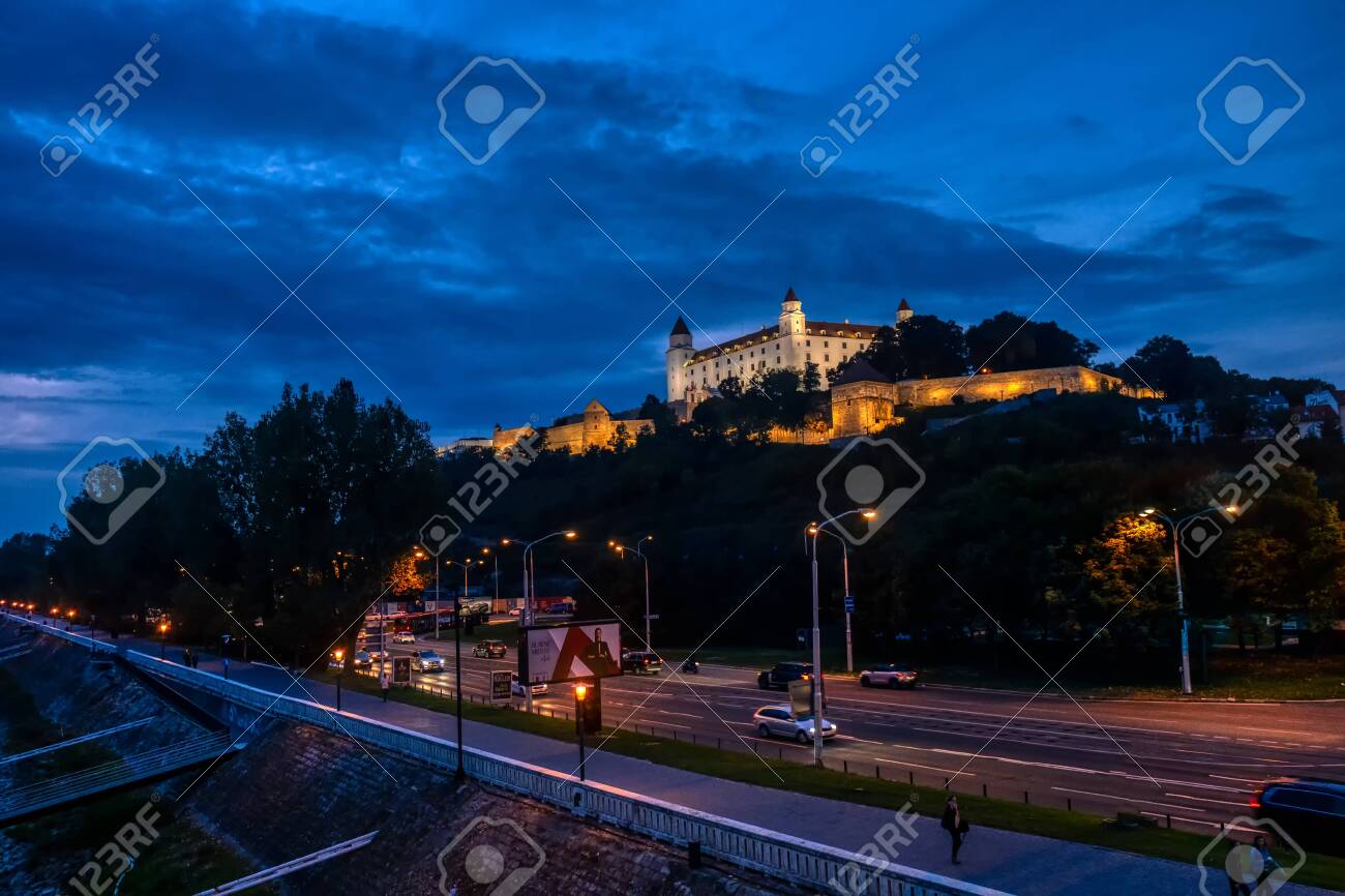 Bratislava, Slovakia - Sept 24 2019: Bratislava castle illuminated in evening glow against dramatic sky, moody and romantic scene of landmark in Slovak capital - 137011830 Bratislava, Slovakia - Sept 24 2019: Bratislava castle illuminated in evening glow against dramatic sky, moody and romantic scene of landmark in Slovak capital - 137011830