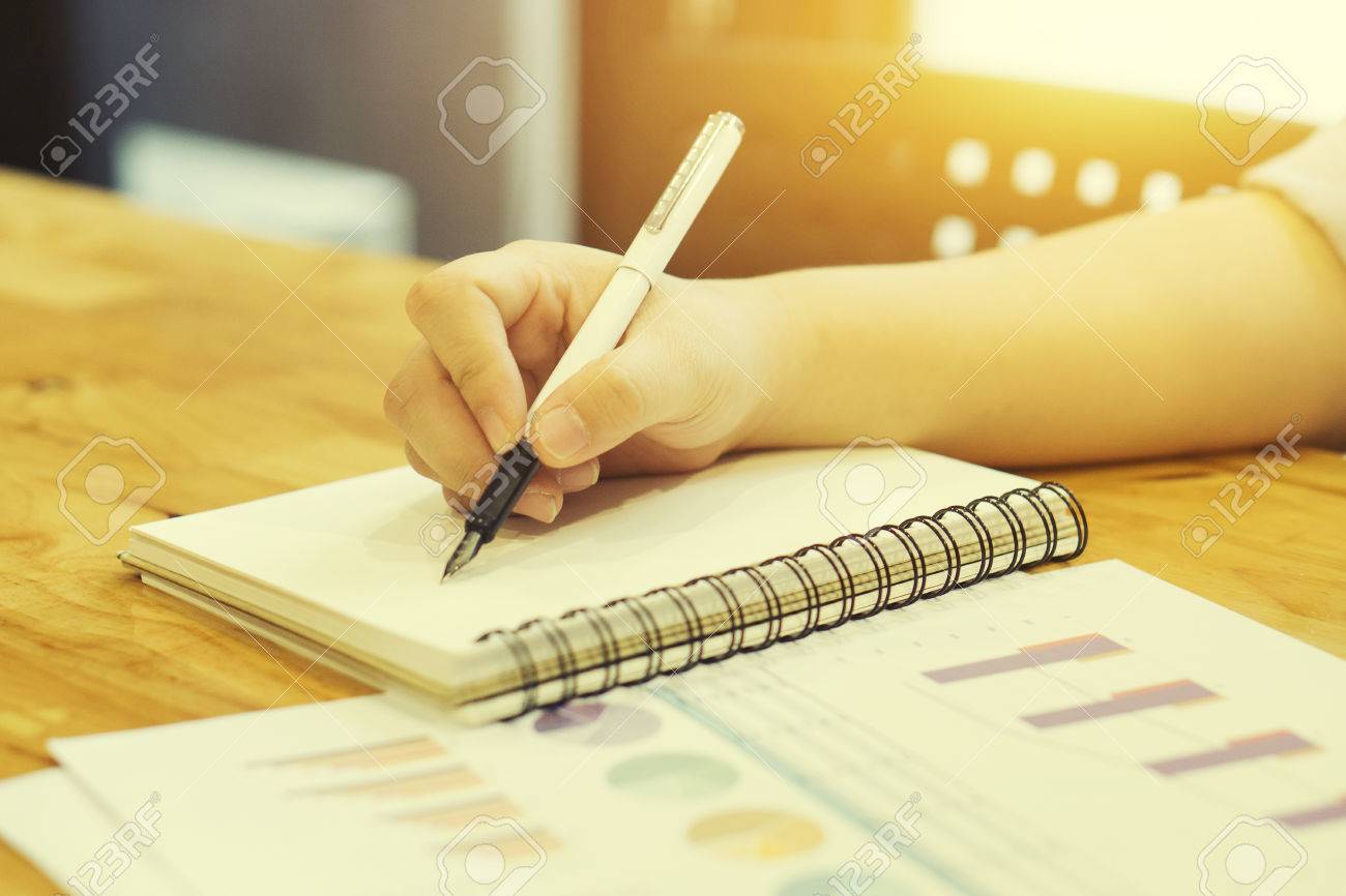 Man Student Writing A Paper With Pen And Reading Books At Table