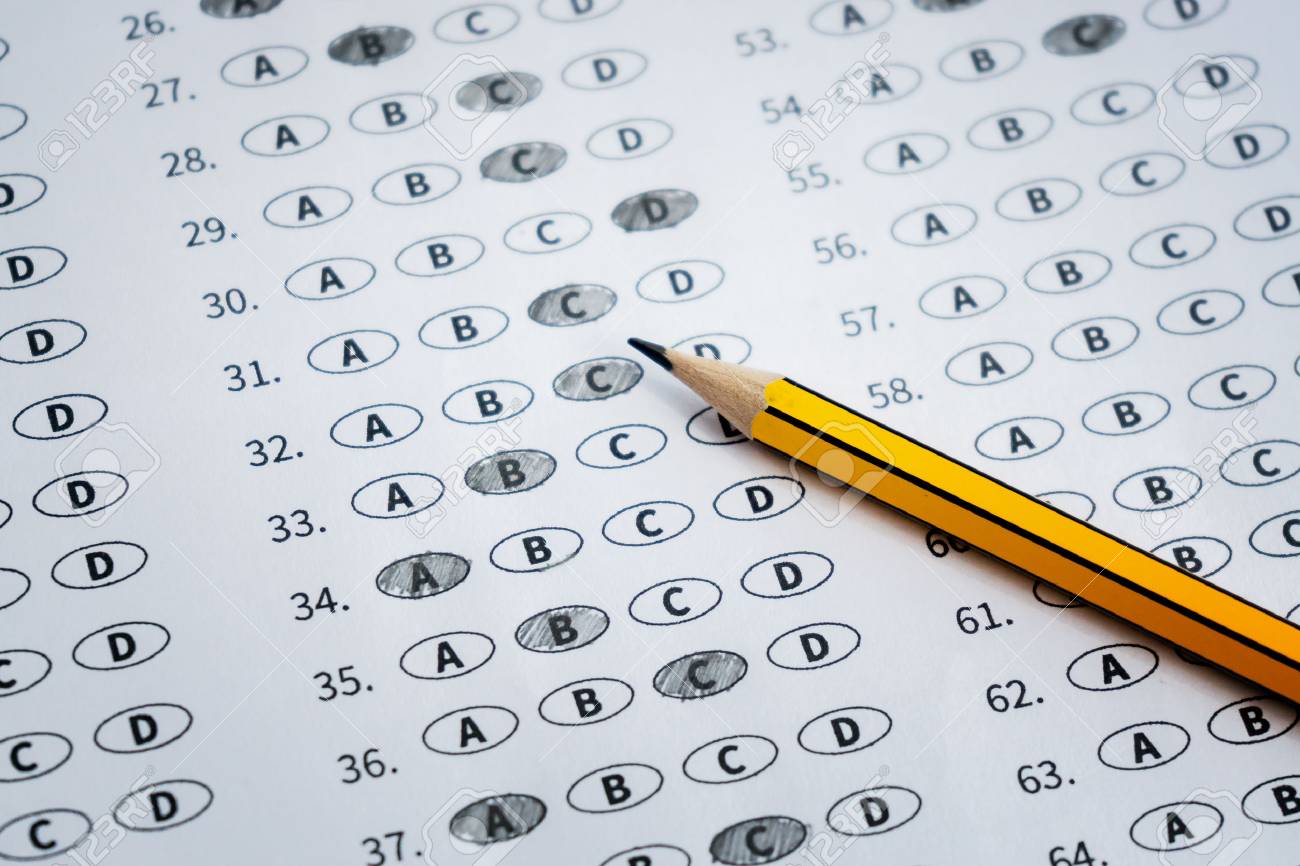 a pencil sitting on a test bubble sheet and alarm clock optical standardized test answer sheet