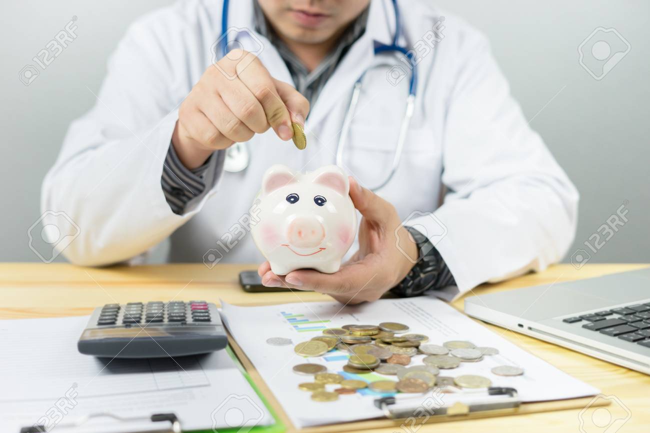 医者の支払をしたいあなたの貯金を保持 有料法案にあなたの貯蓄は 聴診器金融検査や医療保険費のお金プラン料金ライフ スタイル概念のための貯蓄にコインを挿入 の写真素材 画像素材 Image