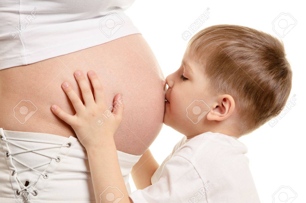 Young boy is kissing the pregnant woman isolated on white background - 13453015 Young boy is kissing the pregnant woman isolated on white background - 13453015