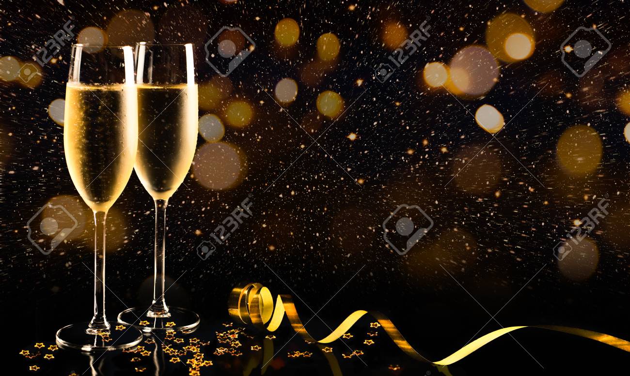 Two glasses of champagne with golden confetti, glitter, serpentine and lights. Night of celebration concept - 87021077 Two glasses of champagne with golden confetti, glitter, serpentine and lights. Night of celebration concept - 87021077