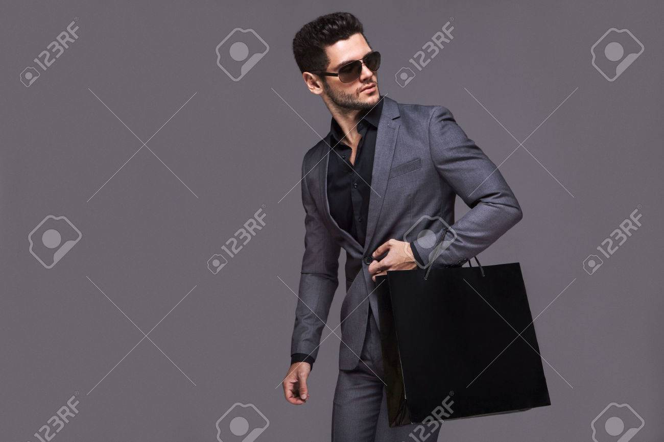 Handsome man in suit with shopping bag - 50580025 Handsome man in suit with shopping bag - 50580025