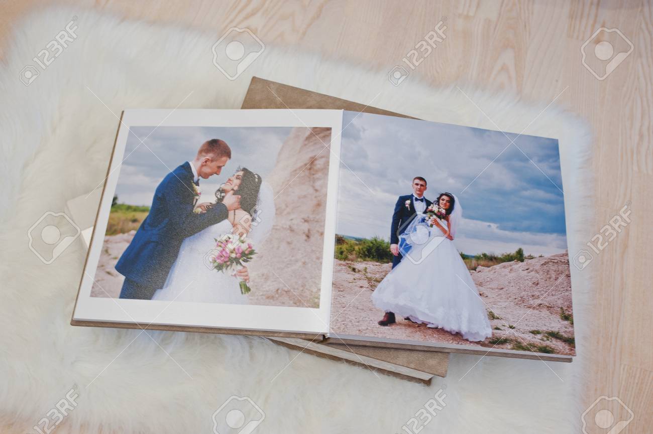 pages of wedding photobook or wedding album at carpet on wooden background album wedding