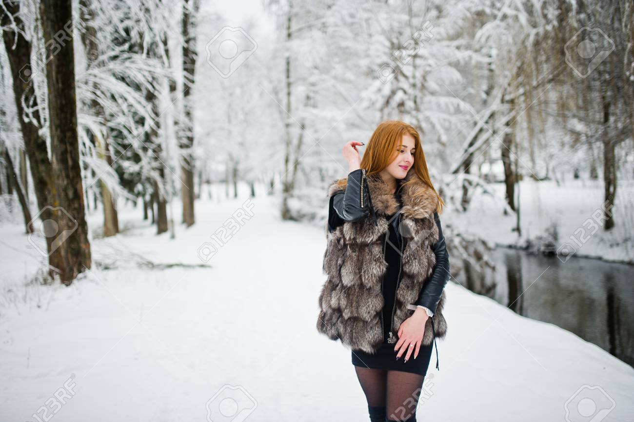 冬の雪の公園を歩く毛皮のコートを着た赤い髪の女の子 の写真素材 画像素材 Image