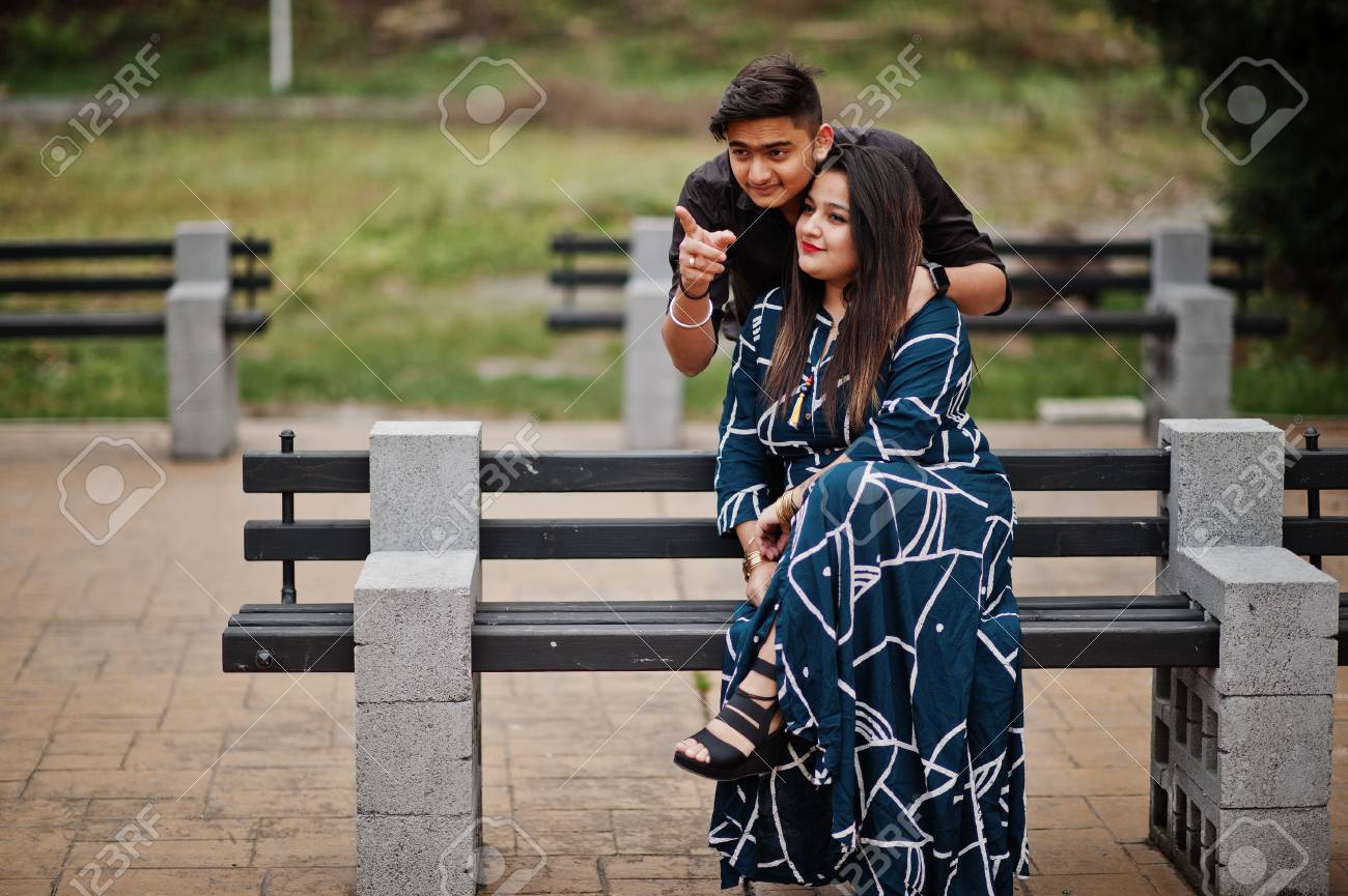 Love Story Of Indian Couple Posed Outdoor, Sitting On Bench Together. Show  Finger Фотография, картинки, изображения и сток-фотография без роялти.  Image 115443996