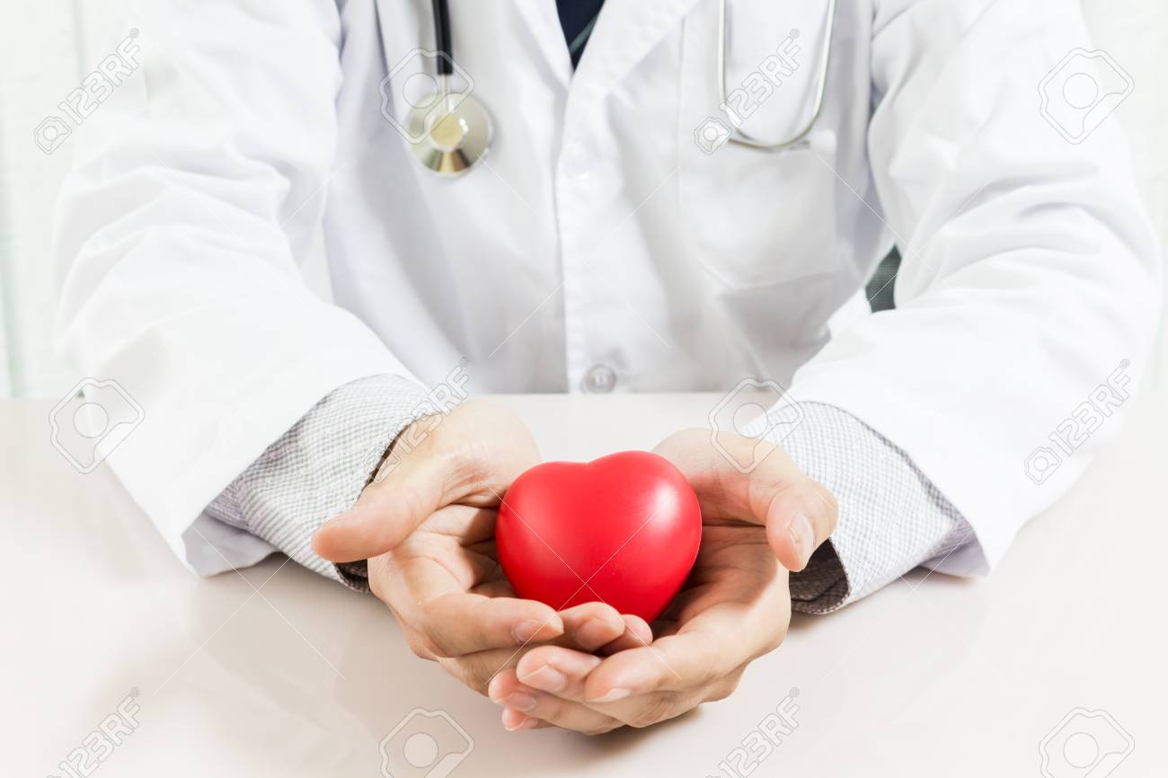 Male doctor with stethoscope holding red heart - 95115193 Male doctor with stethoscope holding red heart - 95115193