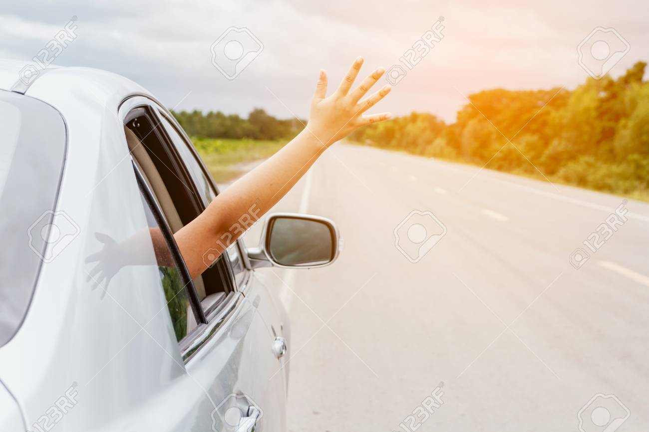 Woman hand in the car relaxing and happy traveler on the road - 97328515 Woman hand in the car relaxing and happy traveler on the road - 97328515