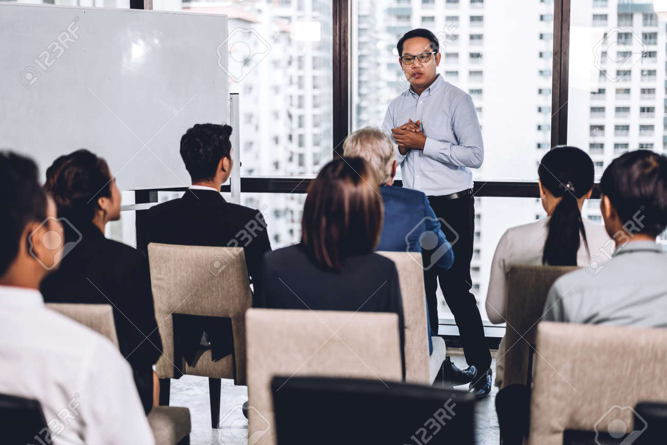 Businessman standing in front of group of people in consulting meeting conference seminar at hall or seminar room.presentation and coaching concept - 155777459 Businessman standing in front of group of people in consulting meeting conference seminar at hall or seminar room.presentation and coaching concept - 155777459