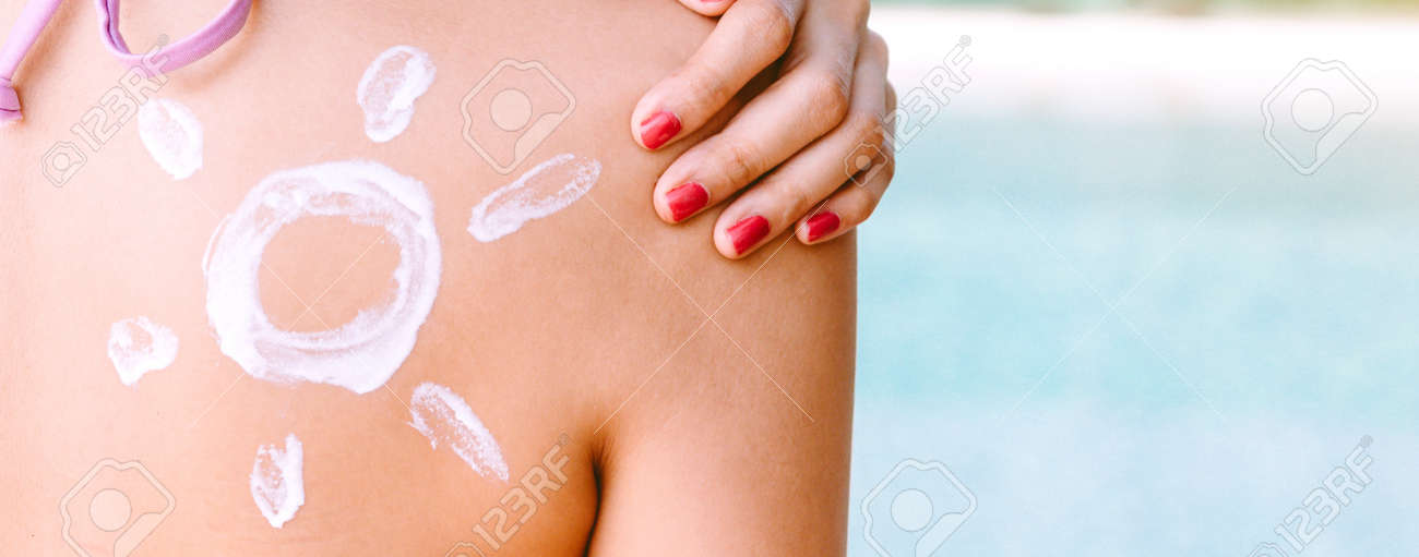 Woman wearing two piece bikini applying suncream with sun drawn on back on the tropical beach.Summer vacations - 168606999 Woman wearing two piece bikini applying suncream with sun drawn on back on the tropical beach.Summer vacations - 168606999