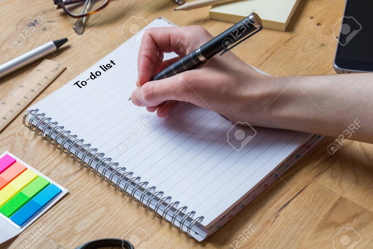 Escribir En El Bloc De Notas Con La Lista De Tareas Y El Lápiz Y Otros Accesorios En Una Mesa De Madera Vista Desde Un Lado Fotos, Retratos, Imágenes Fotografía