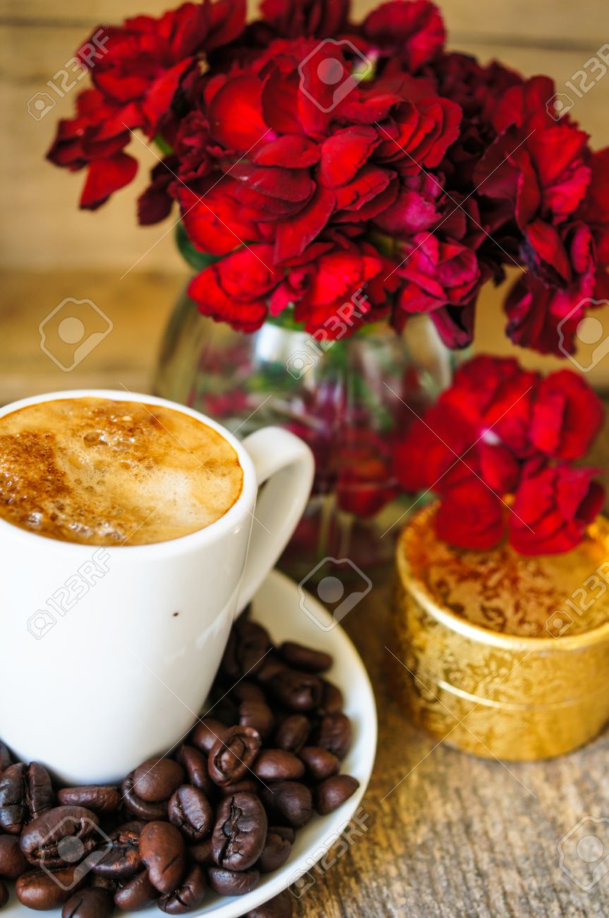 Cup Of Coffee And Red Cloves Flowers In A Vase With Good Morning
