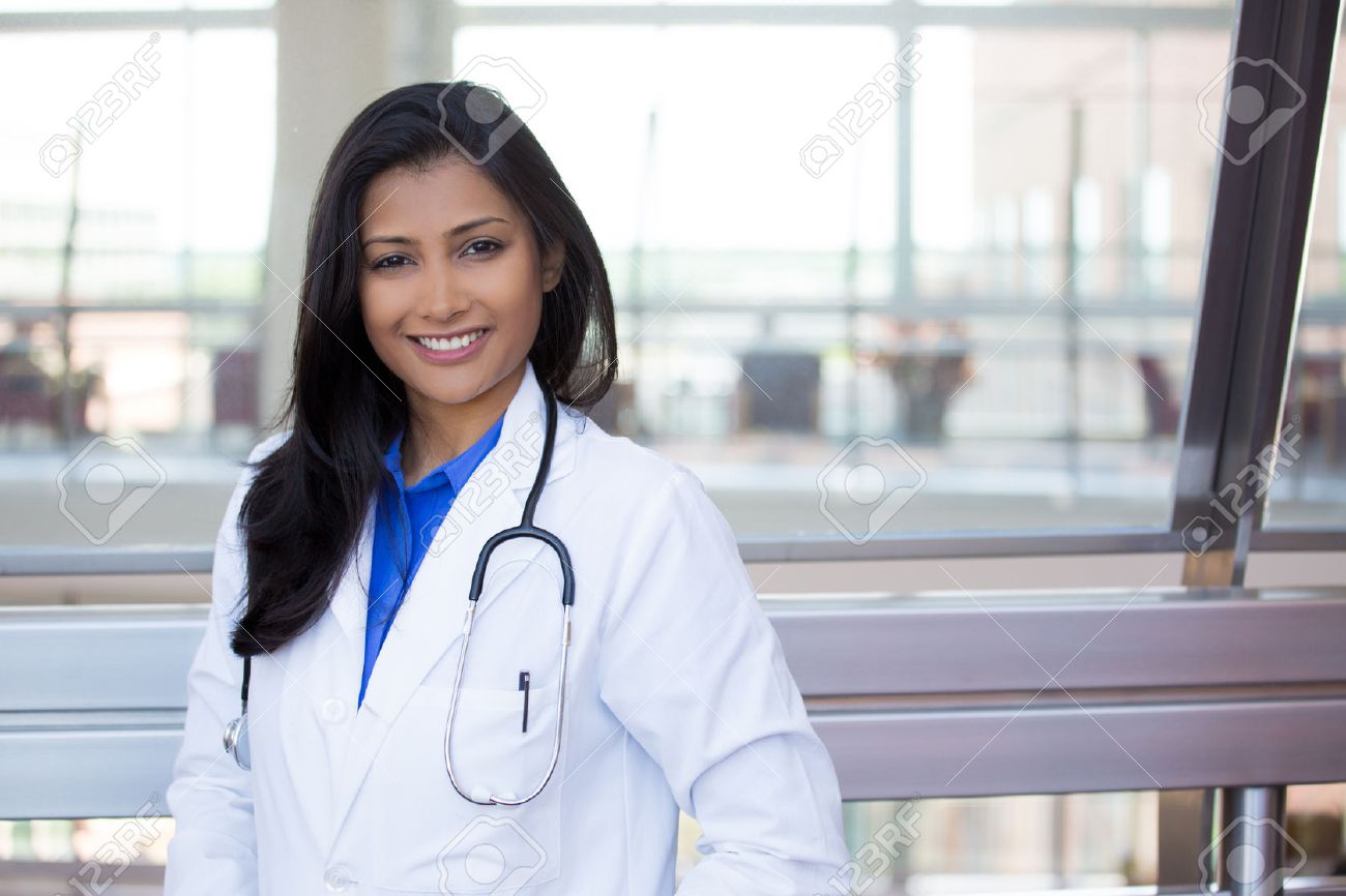 Closeup headshot portrait of friendly, cheerful, smiling confident female, healthcare professional with lab coat. isolated indoor clinic office background. Patient visit. - 52420090 Closeup headshot portrait of friendly, cheerful, smiling confident female, healthcare professional with lab coat. isolated indoor clinic office background. Patient visit. - 52420090