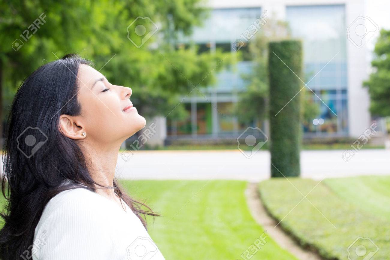 Closeup portrait, young woman in white shirt breathing in fresh crisp air after long day of work, isolated outdoors outside background. Stop and smell the roses, connect with nature - 60873944 Closeup portrait, young woman in white shirt breathing in fresh crisp air after long day of work, isolated outdoors outside background. Stop and smell the roses, connect with nature - 60873944
