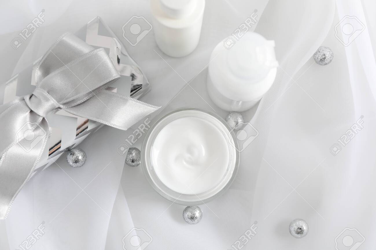 Set cosmetics, jar of winter cream for skin, gift boxes on white fabric background, closeup. Top view - 135192922 Set cosmetics, jar of winter cream for skin, gift boxes on white fabric background, closeup. Top view - 135192922