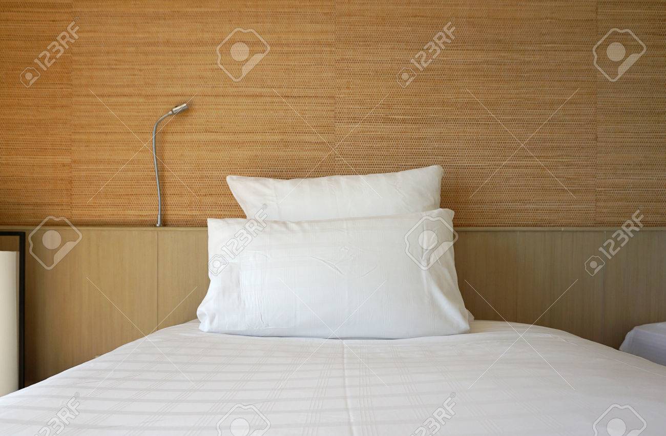 double white pillow on white bed sheet with timber backing and backing sheet