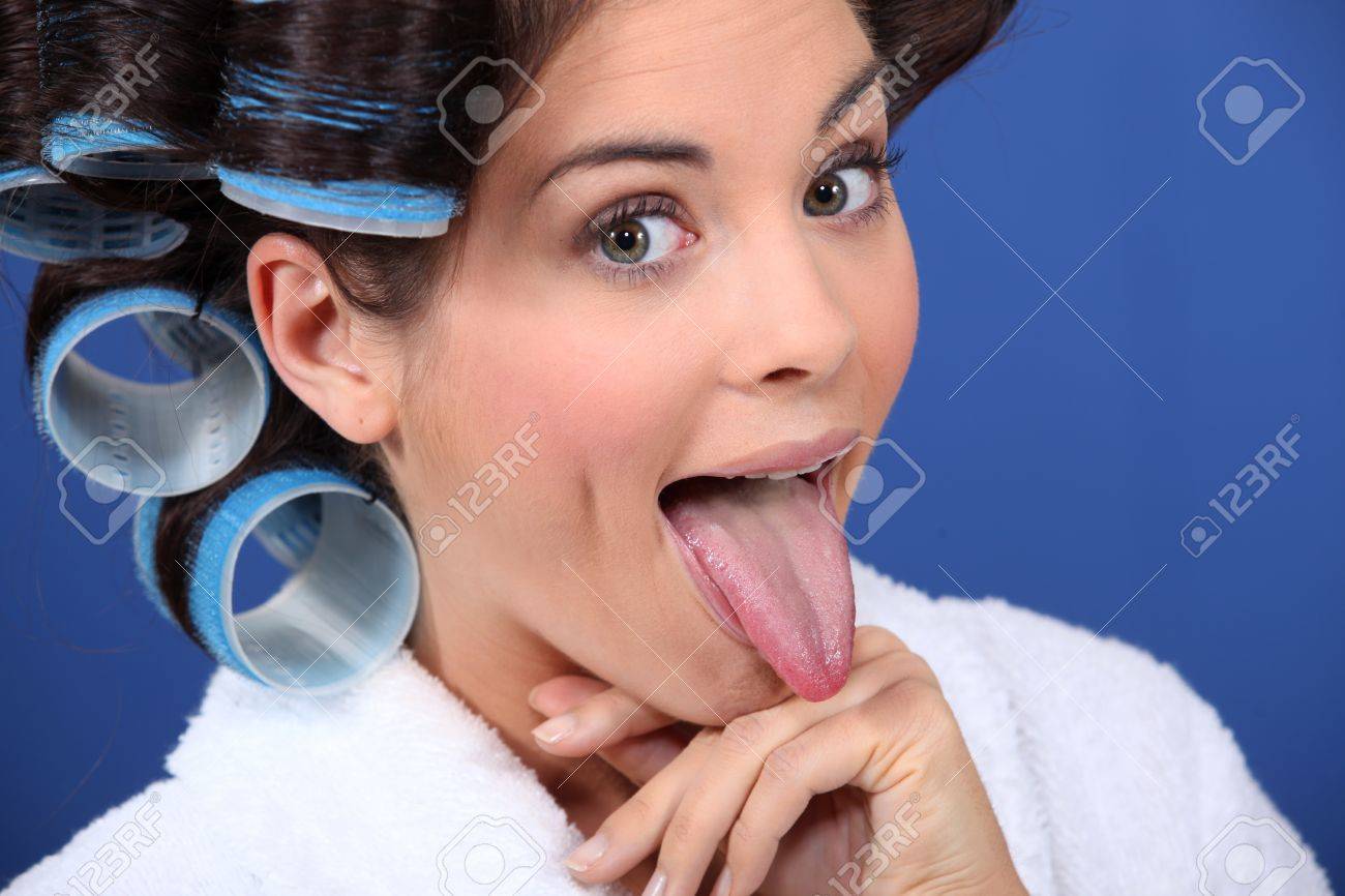 愚かな顔を引っ張って髪のローラを着ている女性 の写真素材 画像素材 Image