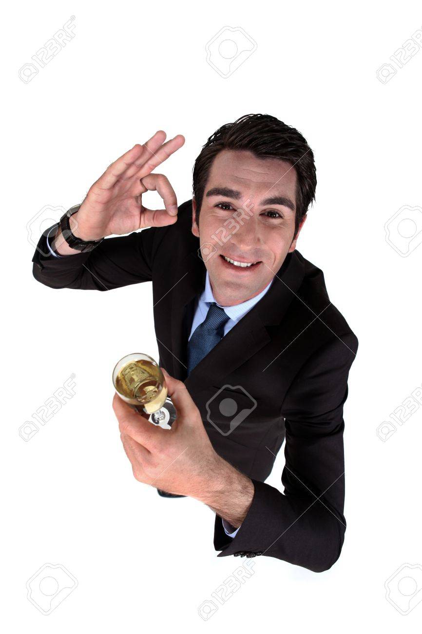 Businessman drinking a glass of wine and giving the a-ok gesture - 13541287 Businessman drinking a glass of wine and giving the a-ok gesture - 13541287