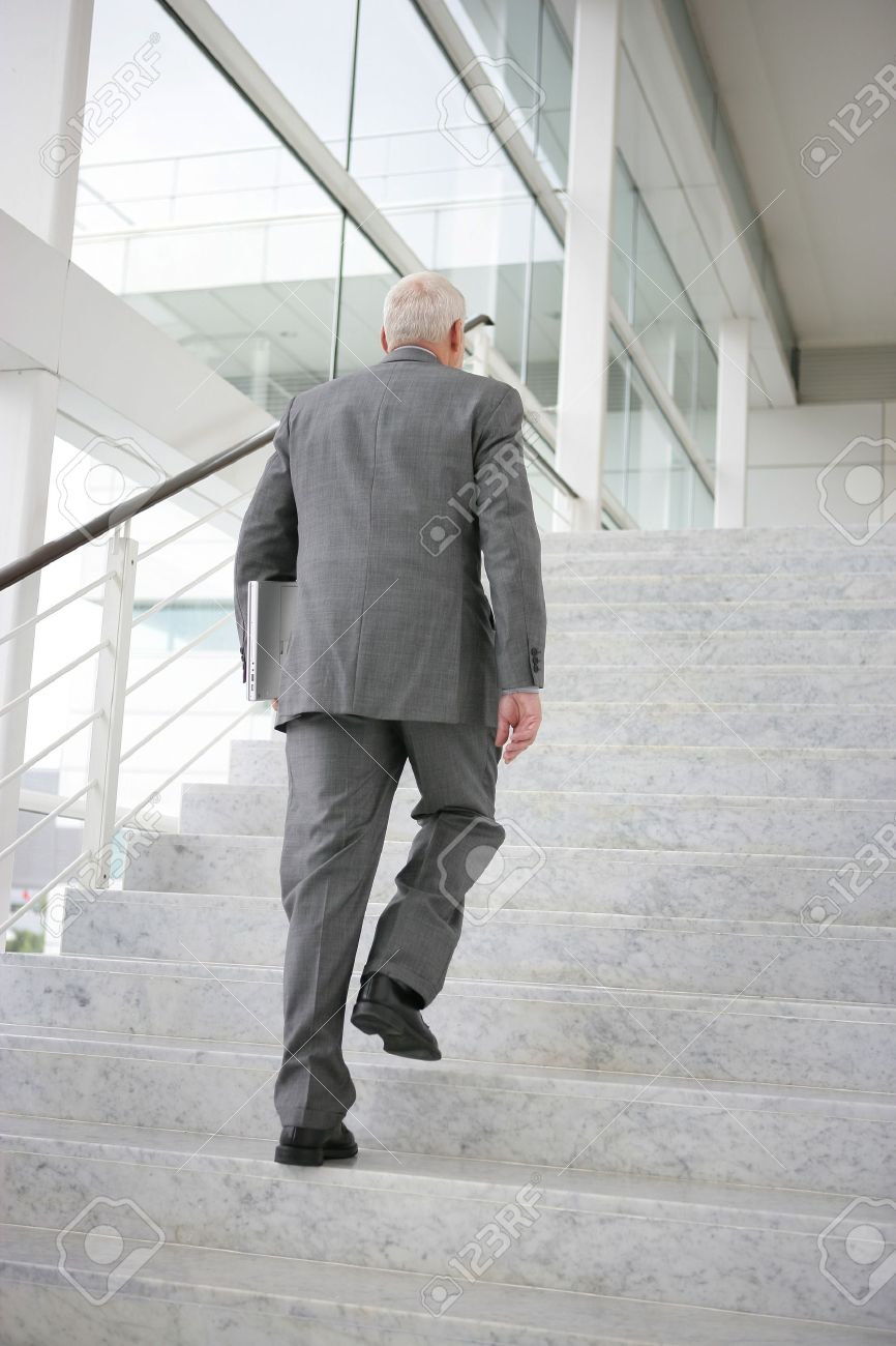 grey haired businessman climbing steps stock photo picture and