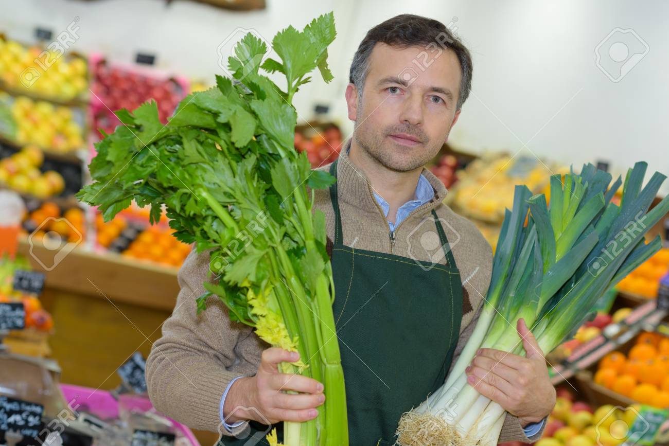 young grocery clerk posing in produce aisle of grocery store produce clerk