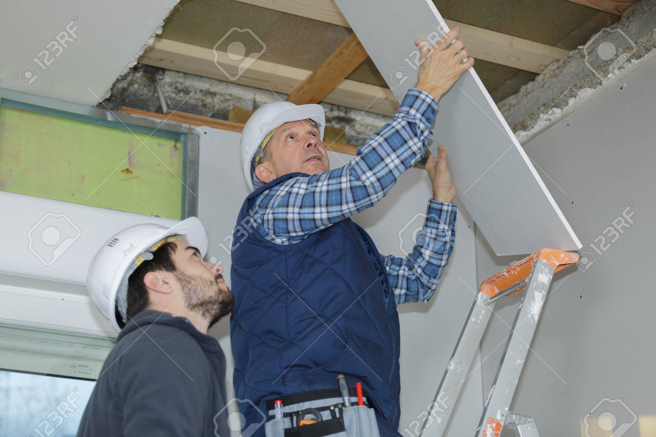 Builder Installing The Rest Of The Drywall On The Ceiling Stock