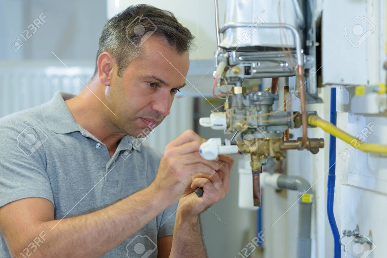 male engineer repairing a gas boiler - 125495867 male engineer repairing a gas boiler - 125495867