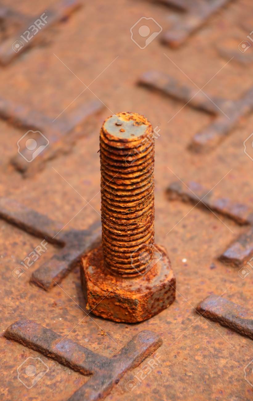 錆びた金属ボルトは、錆びた鉄で茶色の色で鋼板の床に置かれました。錆