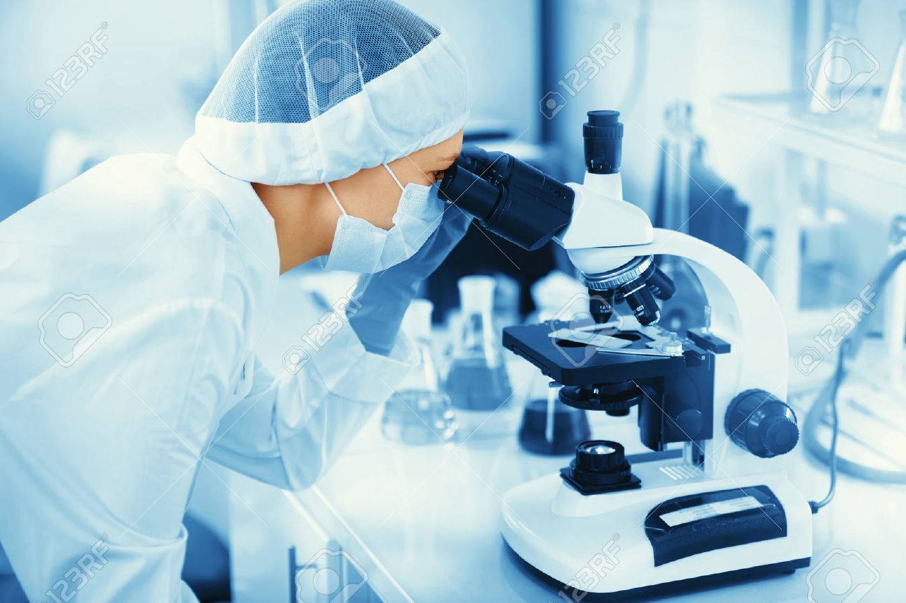 Young woman medical researcher looking through microscop slide in the life science (forensics, microbiology, biochemistry, genetics, oncology) laboratory. Medicine concept. - 50556323 Young woman medical researcher looking through microscop slide in the life science (forensics, microbiology, biochemistry, genetics, oncology) laboratory. Medicine concept. - 50556323