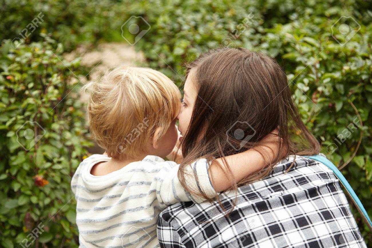 Bacside Schuss Von Mutter Und Sohn Zusammen Umarmen Geheimnisse Im Grunen Garten Flustert Blonde Junge Und Brunette Mutter Hielt Fur Eine Weile Zu Kuscheln Nizza Busche Rund Um Schone Familie Paar Lizenzfreie