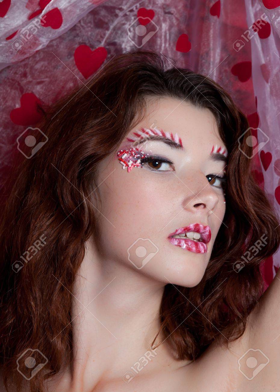 キャンディでメイクの心を保持している赤いドレスでセクシーな女性形の生地 の写真素材 画像素材 Image